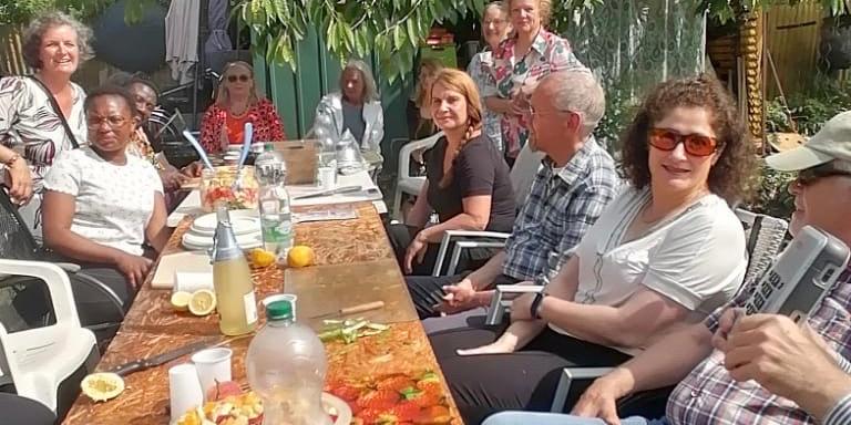 Menschen beim Kochen in einem Garten.