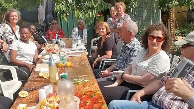 Menschen beim Kochen in einem Garten.