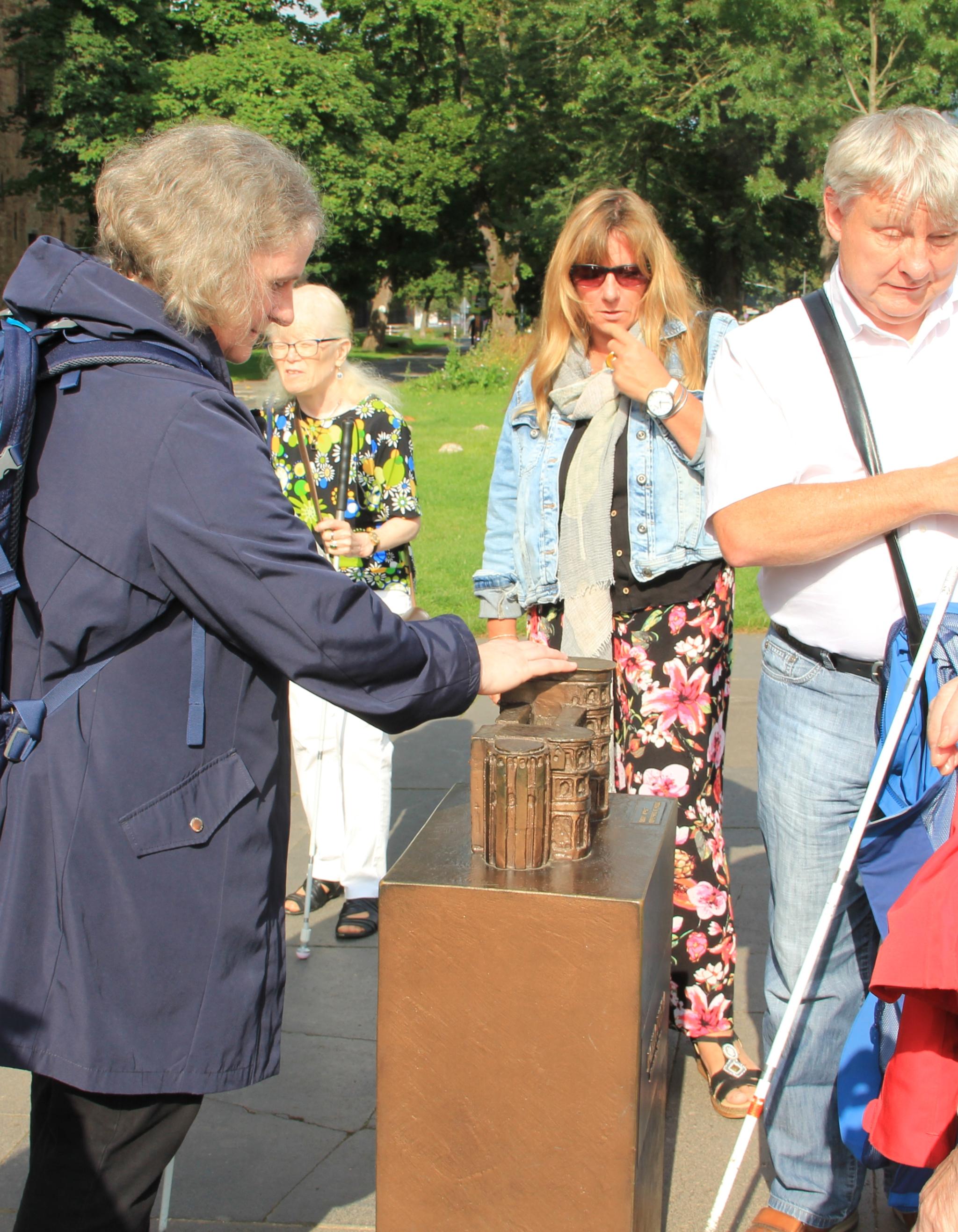 Man sieht Menschen die eine Stadtführung mitmachen